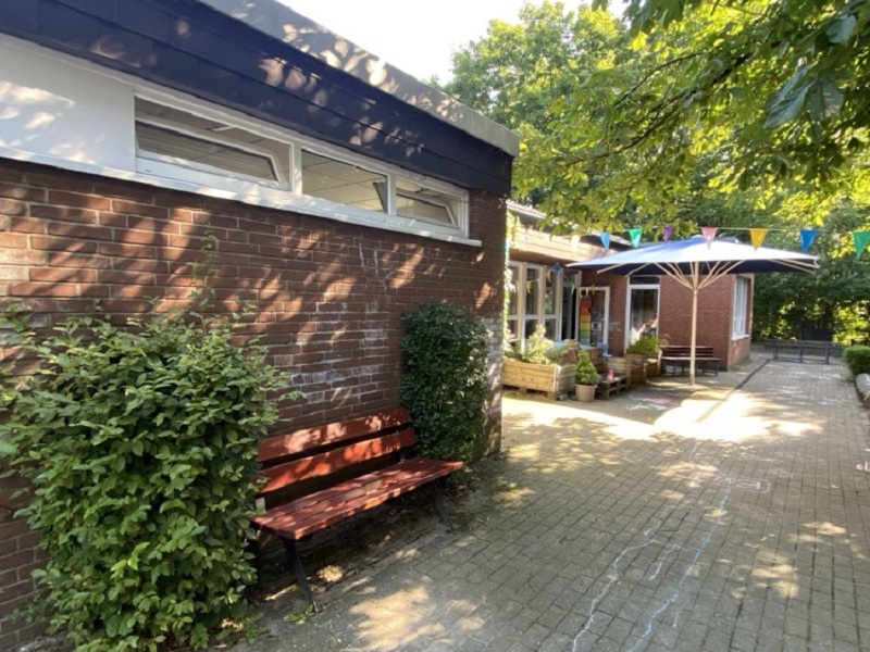 Außengelände - die Terrasse der Rotenen Gruppe mit Blick auf den Außenbereich mit den Spielmöglichkeiten