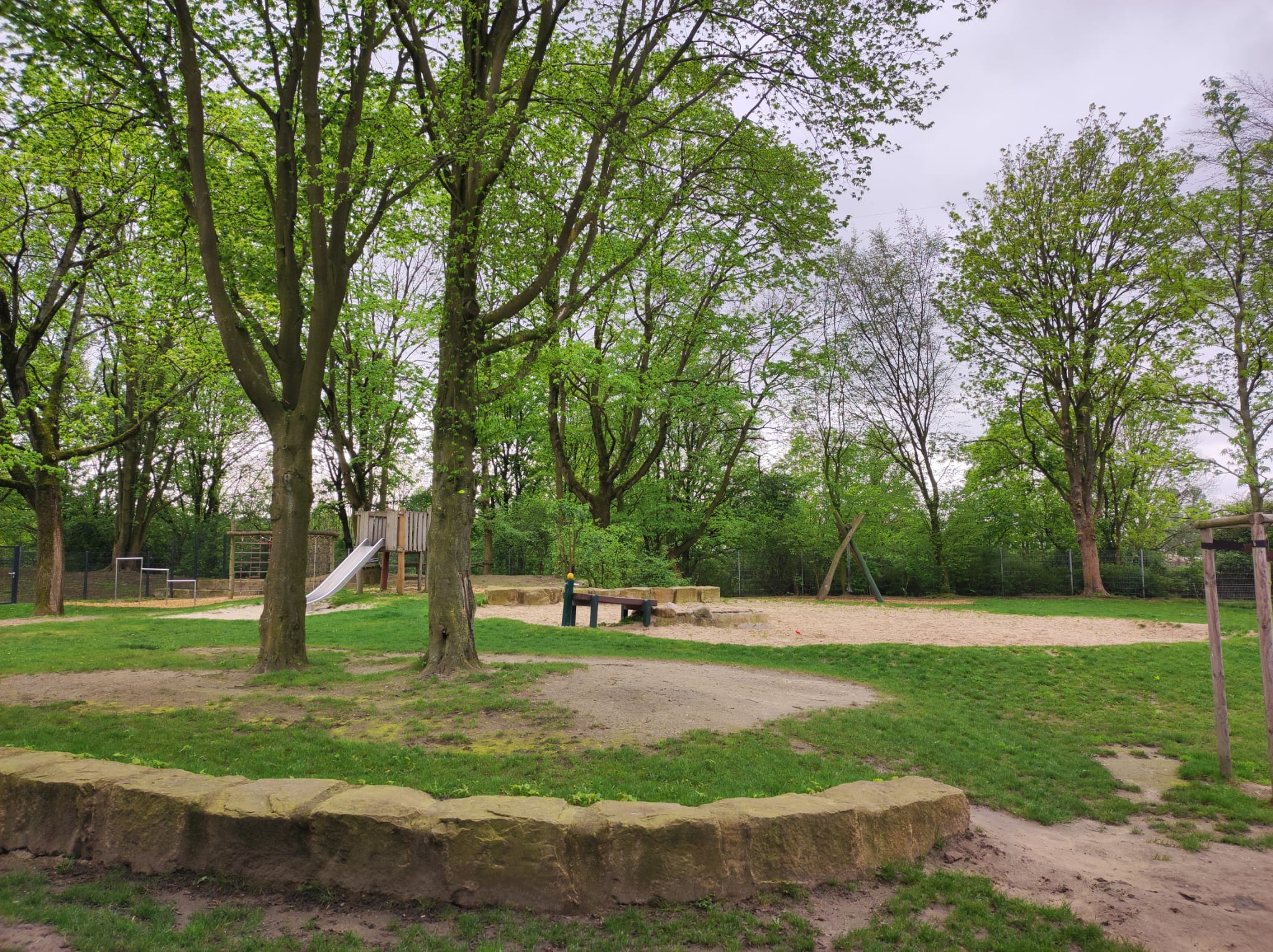 Das große Außengelände mit einer Wasserstation im Sandkasten.